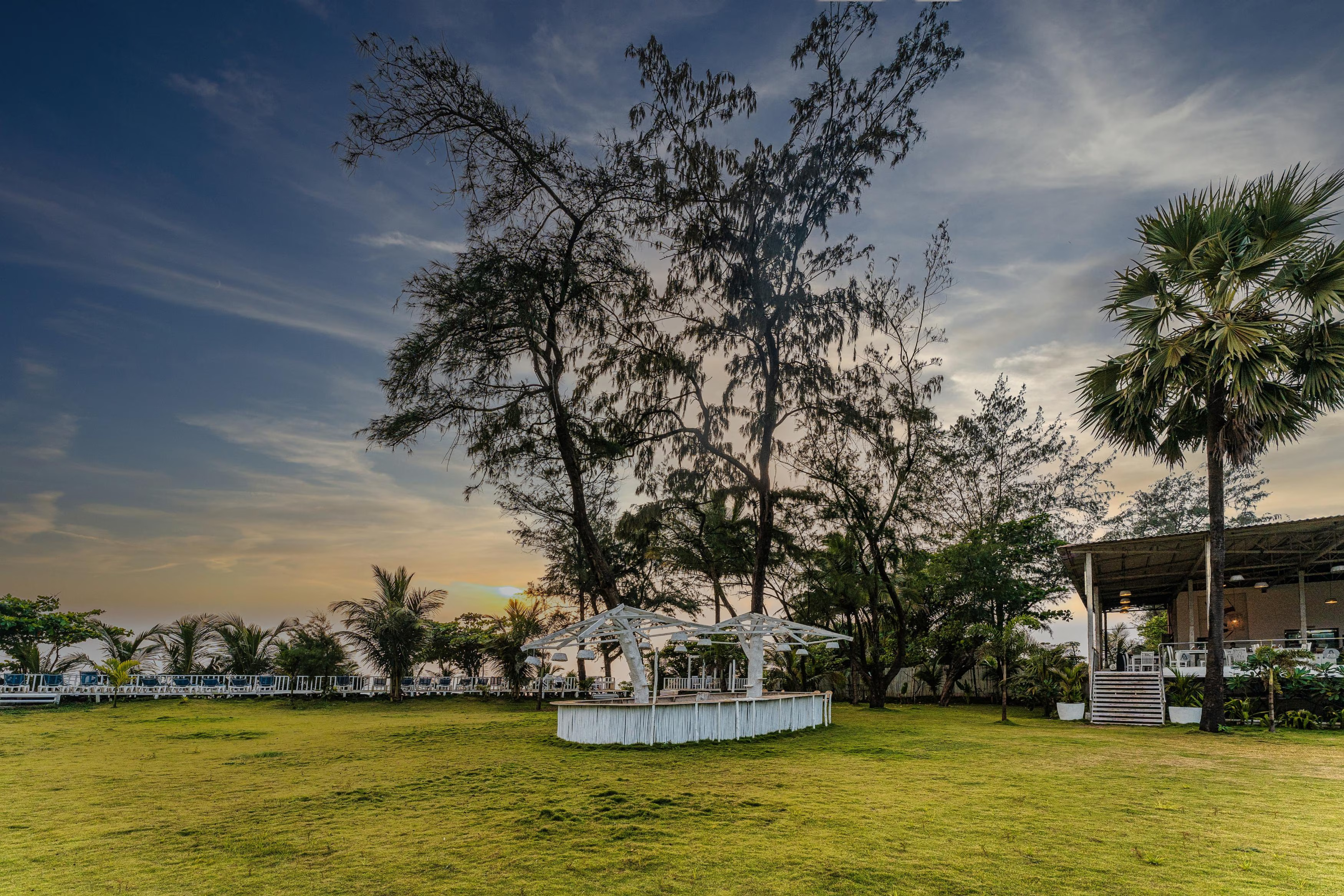 Resort lawns with palm trees at Foxoso La Beach Resort Goa